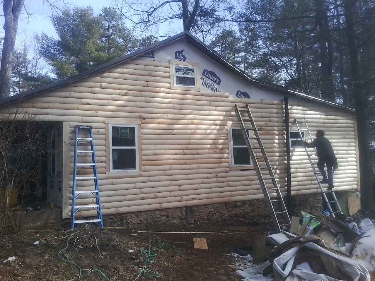 Ladders set against fresh log siding during an exterior remodel in Adamstown