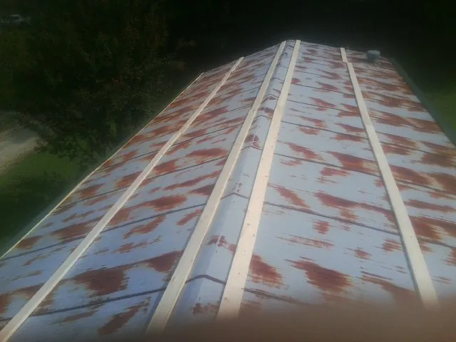Rusted metal roof panels with new wood purlins before replacement — Storm Damage Roof Repair in Adamstown by Roofing Brothers